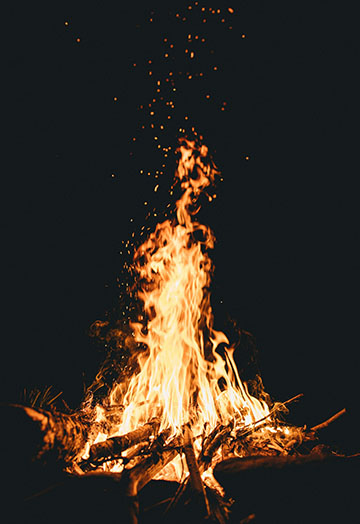 picture of campfire at night with sparks in the sky